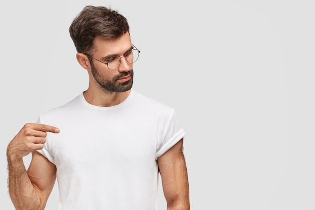 Brunet homme portant des lunettes rondes et un t-shirt blanc