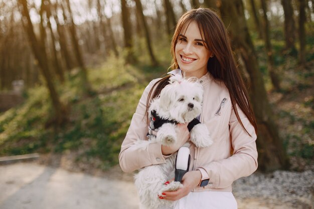 Brunette dans une forêt se promène avec un chien mignon