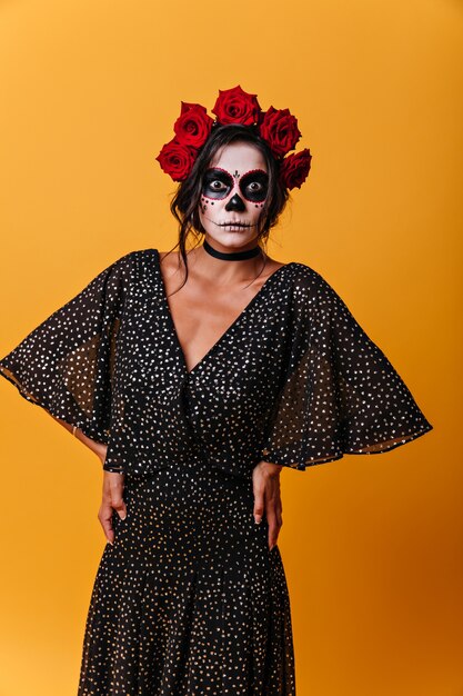 Photo gratuite brunette écarquilla les yeux d'étonnement. fille en robe en mousseline de soie et art du visage pour halloween.