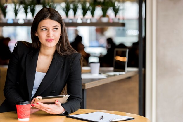 Brunette Femme d&#39;affaires à l&#39;aide de sa tablette