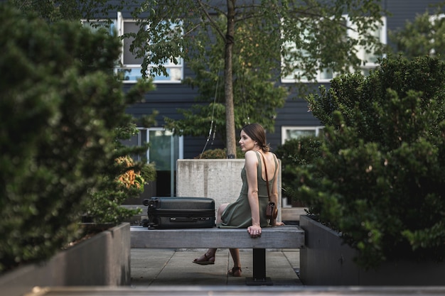 Brunette femme assise sur un siège en ciment sur parc urbain