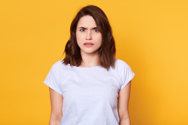 Brunette femme en vêtements décontractés exprimant le dégoût