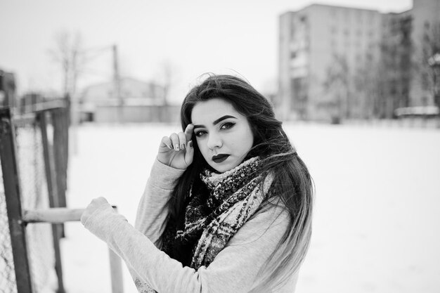 Brunette fille décontractée en écharpe en hiver dans la rue
