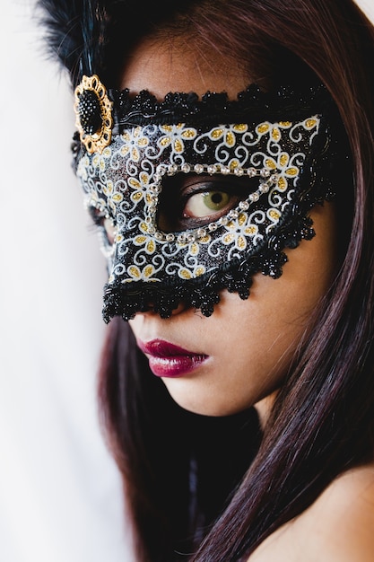 Brunette fille avec un masque vénitien blanc