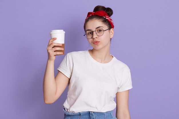 Brunette souriante avec noeud et bandeau rouge portant un t-shirt décontracté blanc