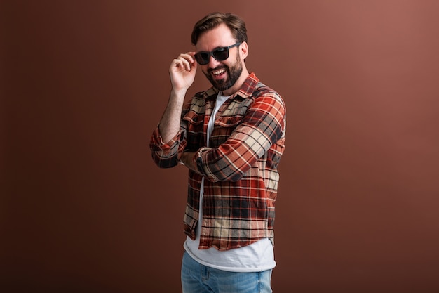 Brutal hipster viril bel homme barbu élégant sur brun