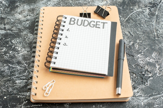 Budget vue avant note écrite sur le bloc-notes avec un stylo sur fond sombre