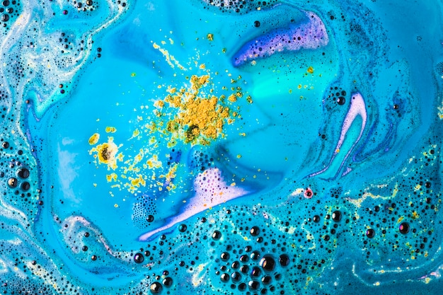 Photo gratuite les bulles de bombe de bain jaunes et bleues dissolvent la toile de fond