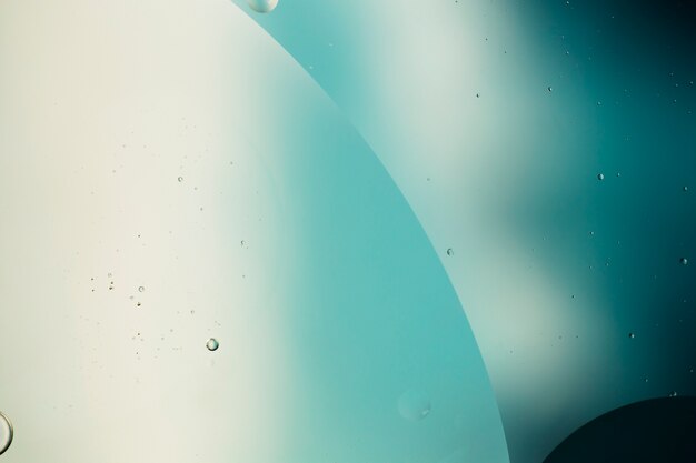 Bulles huileuses transparentes sur fond aqueux de l'espace de copie dynamique
