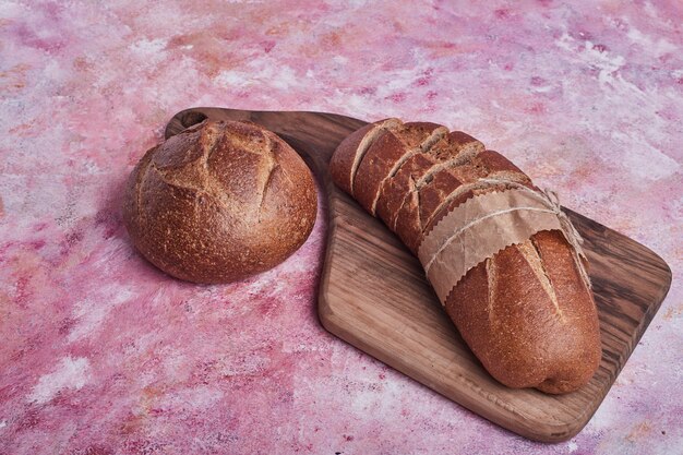 Bun et baguette sur une planche de bois.