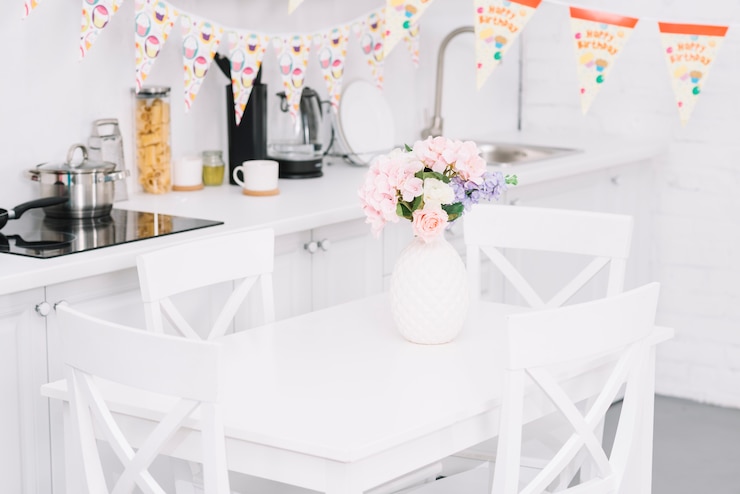 Photo gratuit bunting over table avec beau vase à fleurs dans la cuisine moderne