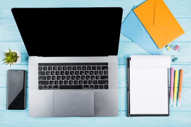 Bureau bleu avec ordinateur portable et matériel scolaire