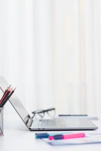 Bureau avec ordinateur portable et lunettes