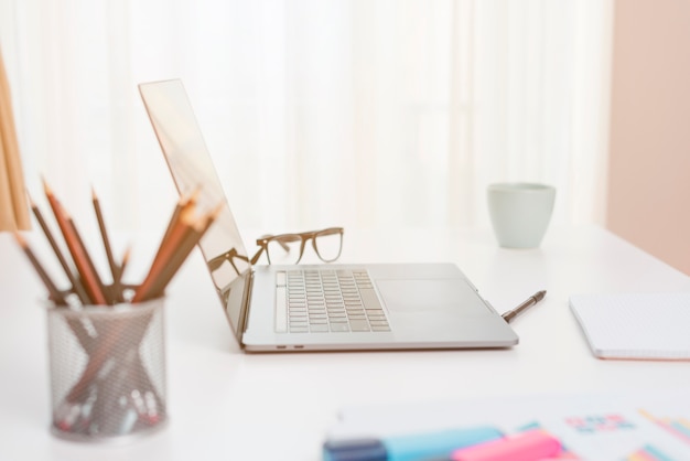 Bureau avec ordinateur portable et lunettes