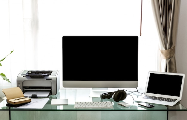 Bureau avec un ordinateur et une table en verre