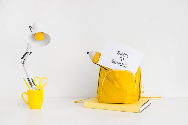 Bureau avec sac à dos jaune vif et étui à crayons