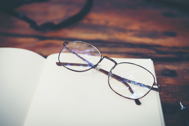 Bureau de travail avec des lunettes et un cahier avec un fond d&#39;espace de copie.