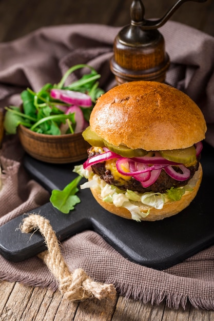 Burger à angle élevé avec des cornichons sur une planche à découper