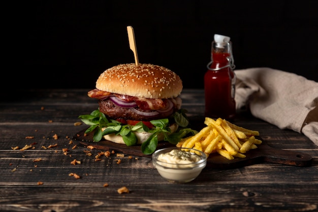 Burger à angle élevé avec frites et sauces sur table
