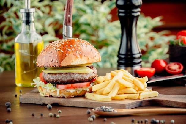 Burger au pain avec de la viande et des frites.