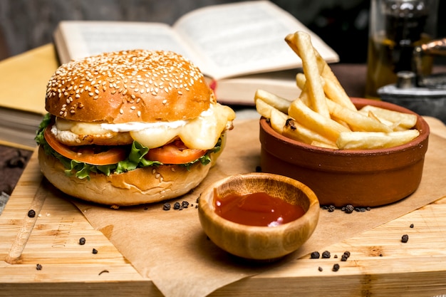 Burger au poulet frites laitue tomate fromage ketchup vue latérale