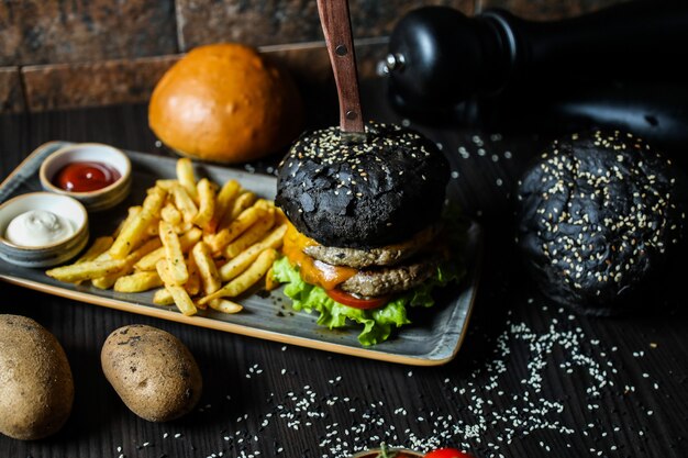 Burger de boeuf noir avec ingrédients et frites