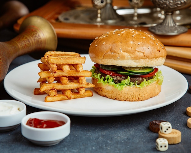 Burger de boeuf servi avec frites, mayonnaise et ketchup