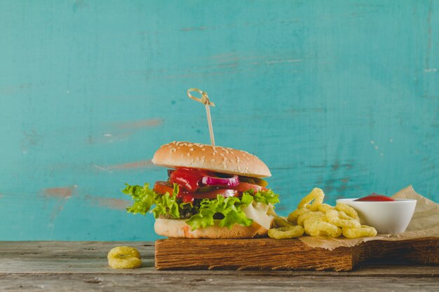 Burger délicieux avec des anneaux d&#39;oignons