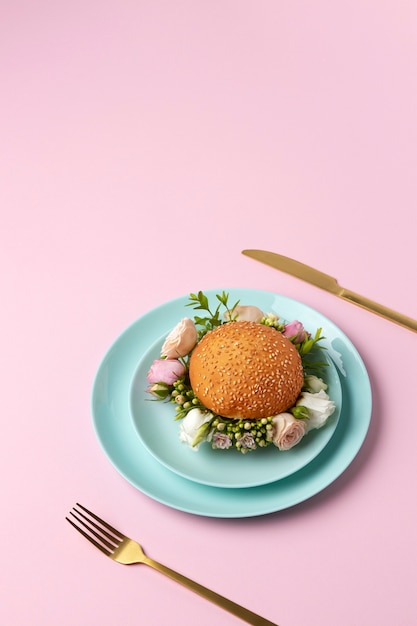 Burger avec des fleurs sur une assiette à angle élevé