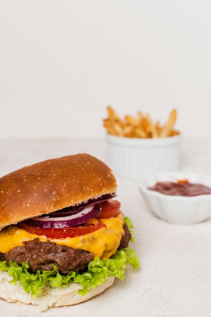 Burger avec des frites sur une table blanche