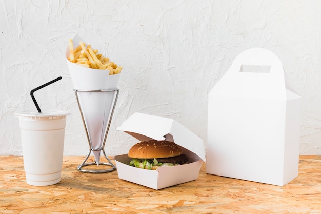 Burger; frites et tasse d&#39;élimination sur table en bois