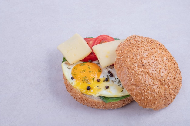 Burger avec omelette, tomates, champignons et oignon.