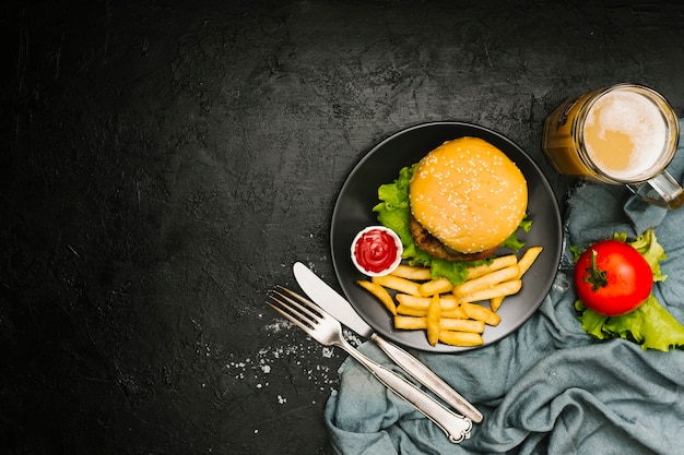 Burger à plat et frites sur assiette avec fond