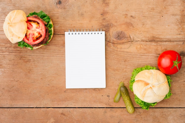 Photo gratuite burger à plat avec maquette du bloc-notes