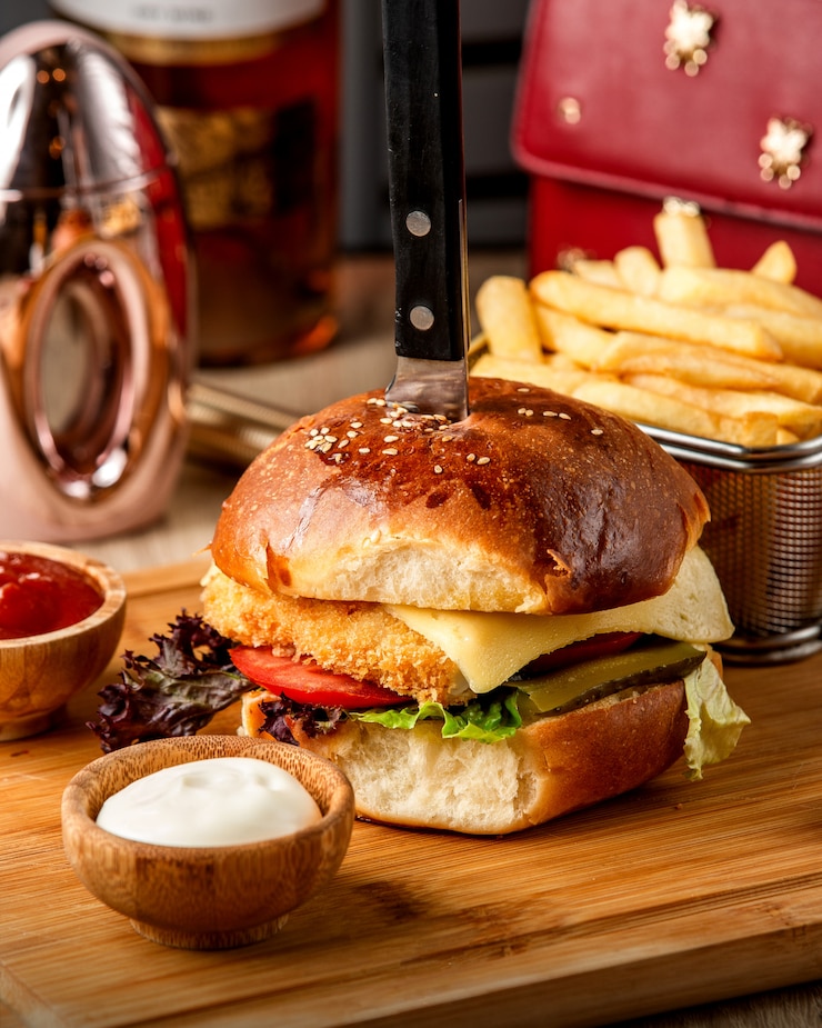 Photo gratuit burger de poulet avec du fromage sur la table