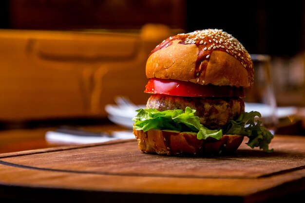 Burger de poulet sur la planche de bois vue latérale