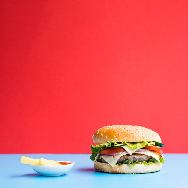 Burger sur une table bleue avec un fond rouge