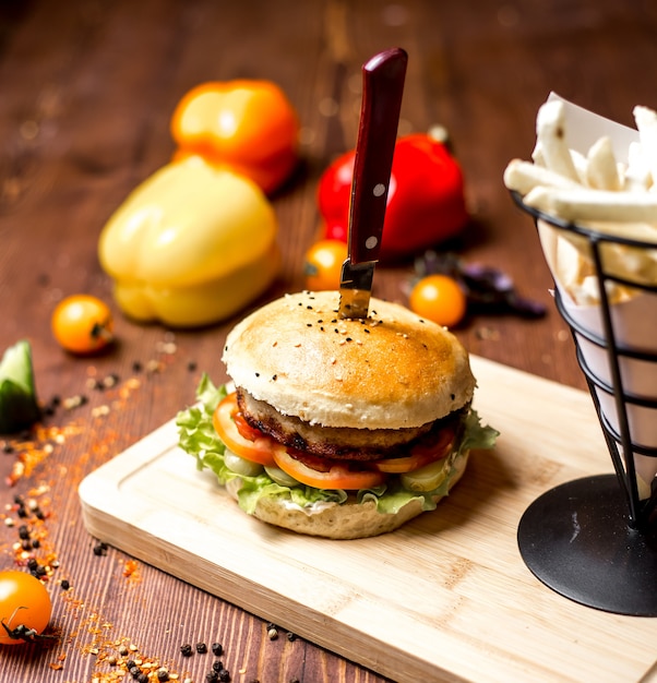 Burger de viande laitue tomate concombre en pain avec vue latérale sésame