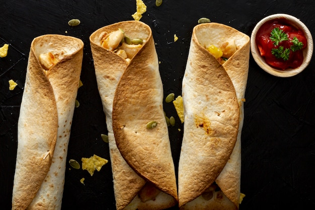 Photo gratuite burritos au four avec poulet et sauce rouge dans une tasse