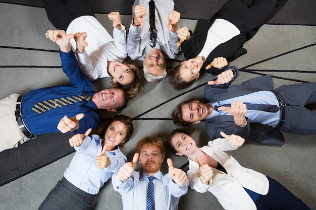 Business Team Gai montrant thumbs up sur le plancher