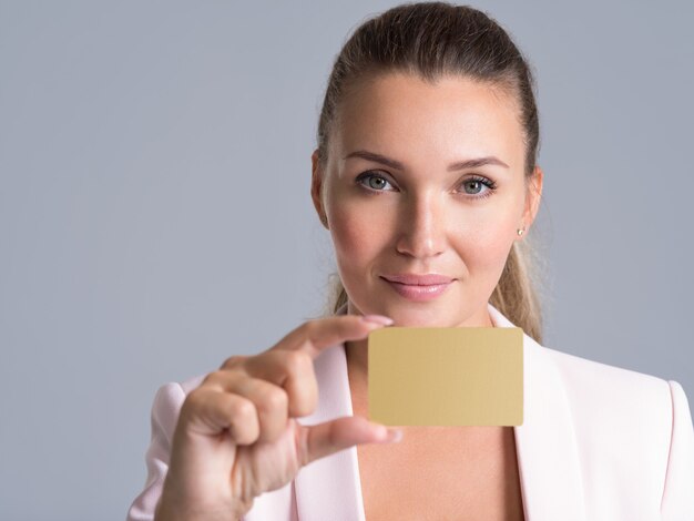 Business woman holding carte de crédit contre ses lèvres portrait studio isolé