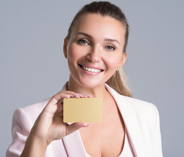 Business woman holding carte de crédit contre son visage portrait studio isolé