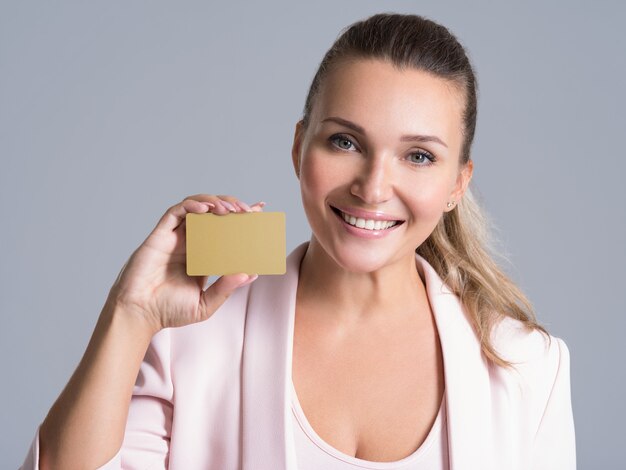 Business woman holding carte de crédit contre son visage portrait studio isolé