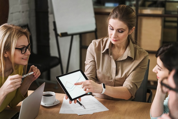 Photo gratuite businesspeople using tablet lors d'une réunion