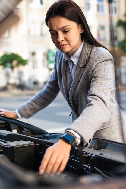 Photo gratuite businesswoman contrôle le moteur de la voiture