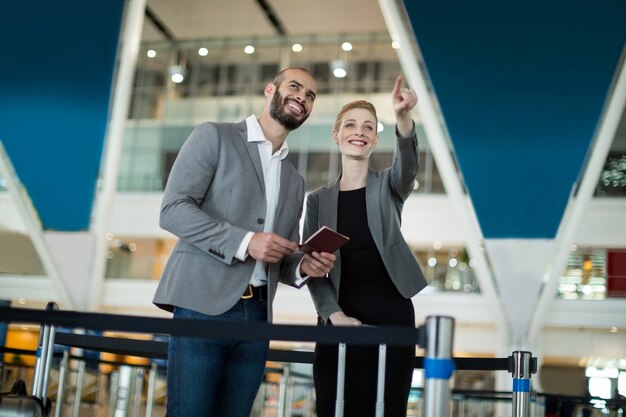 Businesswoman debout avec son collègue et pointant vers la distance