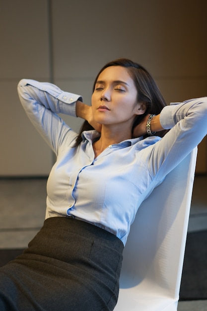 Photo gratuite businesswoman fermer les yeux et reposer sur une chaise