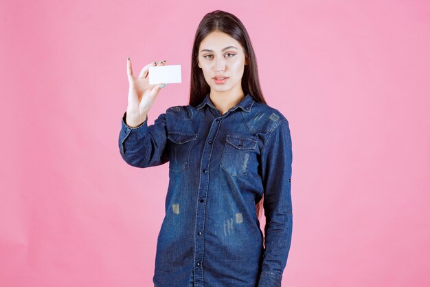 Businesswoman holding et présentant sa nouvelle carte de visite