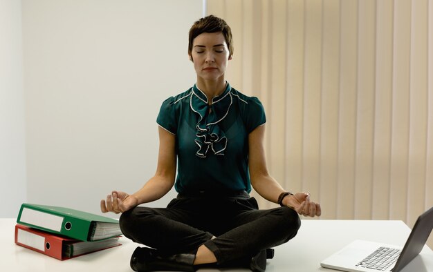 Businesswoman pratiquant le yoga au bureau