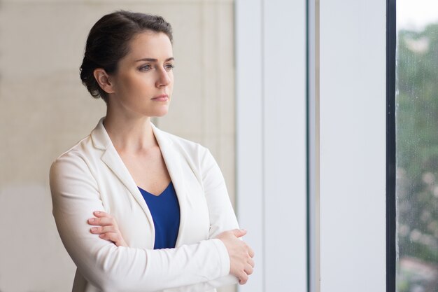 Businesswoman Réfléchi Regarder par la fenêtre